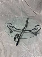 Top view showing round clear glass top and cast iron base with scroll design.