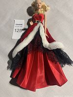 Full length shot of Christmas Barbie doll wearing red satin gown with black lace and white faux fur trim, rhinestone buckle on belt