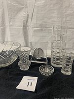 Five crystal pieces arranged on black cloth including three vases, one bowl, and a Mikasa crystal clock.