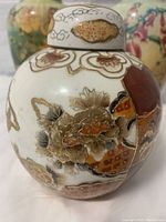Close-up of the ginger jar exterior showing detailed floral and butterfly gold accents