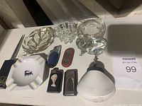 Overview photo showing all items on table including ashtrays, lighters, glass bowl, and tool.