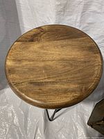 Top view of the solid wood round stool seat showing wood grain and finish.