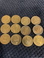 Top view of 12 provincial commemorative coins showing different crests and coats of arms with various dates
