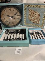 Full view of all items including the cutlery sets, serving spoons, wall clock and shell art in original boxes.