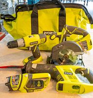 Set of four Ryobi cordless power tools and one Ryobi carry bag on a white surface