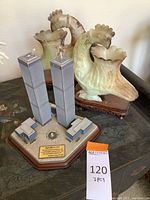 Photo showing both the architectural Twin Towers sculpture and the two jade bird-shaped vases on wooden stands together.