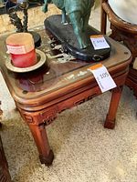 Side and corner views of the square wooden table with carved legs and glass top showing the mother of pearl inlay underneath.