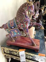 Front angle of horse sculpture showing head, body, wooden base