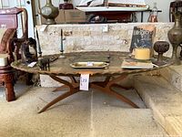 Full front view of oval table with scalloped metal top and wood base
