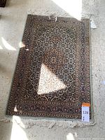 Full top view of the Persian rug showing floral medallion design and bordered edges.