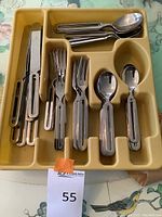 Yellow cutlery tray with stainless flatware arranged by type