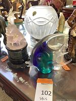 Lot showing three items on table: Waterford crystal bowl on stand, frosted goats statue, and colorful blown glass fish.