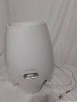 Front perspective view of the white Air-O-Swiss humidifier showing the control switch and oval base.