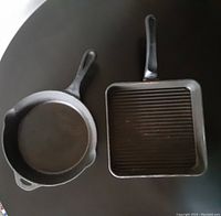 Photo of two cast iron pans, one round frying pan and one square griddle pan with ridges, on a dark surface.