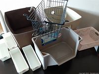 Photo showing various storage and organization baskets and bins including fabric baskets, wire basket with handle, and multiple plastic bins and trays.