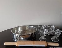 Photo showing the four vintage glass sundae dishes, springform pan, and wooden rolling pin together from side angle