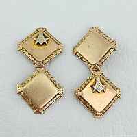 Pair of 10K gold Masonic cufflinks on a white background showing design and wear.