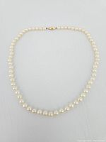Full view of the pearl necklace showing the entire strand and clasp.