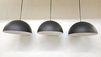 Front view of the three black dome pendant lights hanging, showing shape and size.