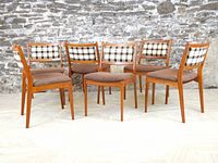 Front view of all six chairs arranged in a semicircle against a stone wall