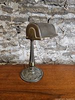 Full side view of the antique desk lamp showing fluted stem and ornate base