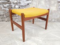 Footrest with teak frame and yellow upholstery from side angle