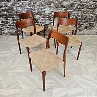 Five teak dining chairs arranged in group view showing frames and woven seats