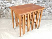 Rectangular table nested over four round tables on casters