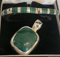 Front photo showing bracelet with rectangular malachite stones and pendant with large malachite stone inside a box.