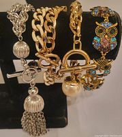 Front view showing all four bracelets on display stand, showing metal tones and clasp styles