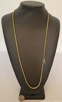 Gold filled watch chain displayed on black stand showing full length and clasp