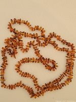 Full view of the amber necklace laid flat showing the amber beads and their natural color and shape.