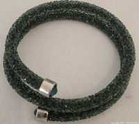 Full view of the double-wrap green Swarovski crystal bracelet showing the sparkling crystals and metal end caps.