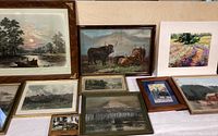 Photo showing an array of framed farm and mountain life art and old photographs arranged together.