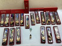 Full collection of 18 red-boxed gold-plated spoons by year plus a central enameled fork