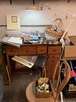 Front view of wooden desk with various crafting items on top and chair in foreground