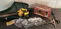 Wide view of chainsaw, case, sharpener, chains and tools