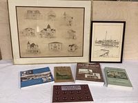 Overall view of two framed drawings and five books