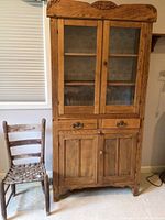 Front view of oak farmhouse hutch and primitive chair side by side, showing condition and proportions