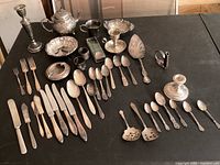 Wide view of all flatware and serveware laid out on black table
