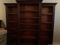 Three wood bookshelves side by side showing overall design