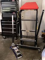 Floor jack and creeper side by side in garage setting