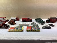 Front view of assorted vintage Texaco vehicles and classic die-cast car models with two Heljan HO Con-Cor model boxes on a white cloth