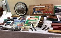 Front view showing wall clock, wooden plaque, assorted toy cars, photo albums, brass whistle and tools