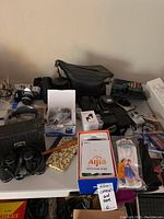 Overview of all items on table showing camera, binoculars, bags, earbuds and gloves