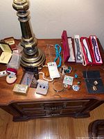 Main overview of all jewelry items displayed on wooden table with lamp base partially visible