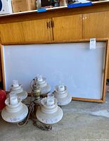 Photo of wood framed lighted display sign with white translucent panel, leaning against wooden cabinets.