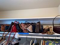 Row of assorted purses and handbags on a shelf