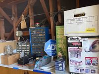 Wide view of lot showing blue hardware storage drawers, assorted hardware boxes and jars, Shark Steam Blaster box and other storage items.