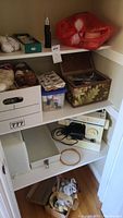 Shelf with assorted sewing storage boxes, threads, and notions